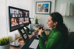 Woman discussing business on virtual staff meeting while working remotly